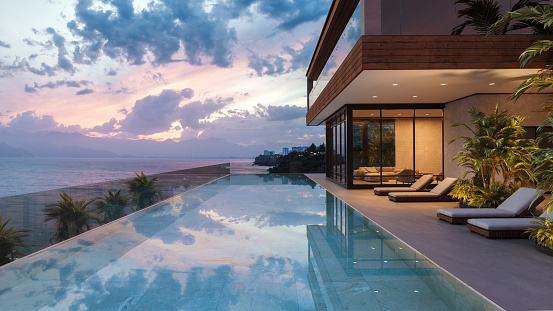 Luxury modern house with swimming pool and beautiful sea view at dusk.
