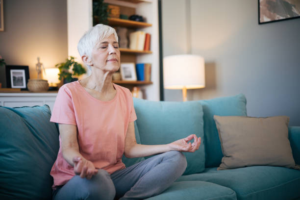 istock Senior woman meditates at home 2110316020