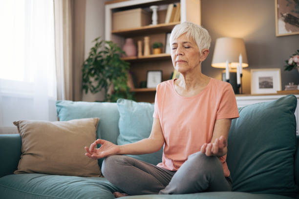 istock Senior woman meditates at home 2110318521