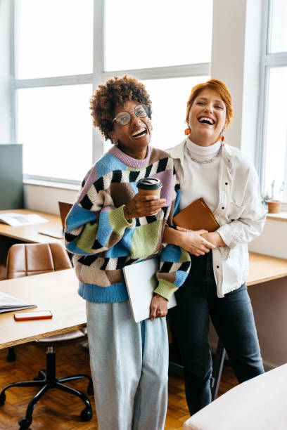 istock Diverse colleagues laughing together in a modern co-working space 2110337085