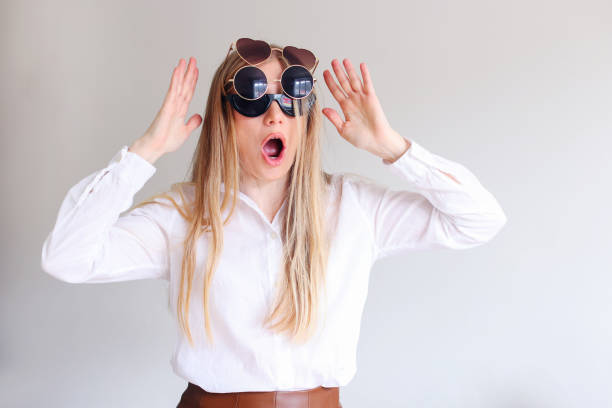 istock girl chooses sunglasses on a white background 2110346413