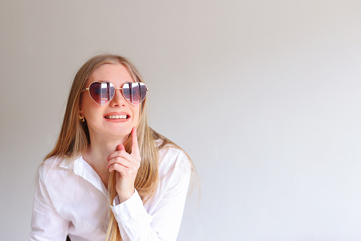 girl in black sunglasses on a white background, copy space for text