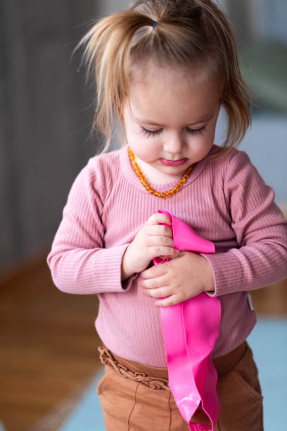 istock a little girl is holding an exercise band in her hands 2110358737
