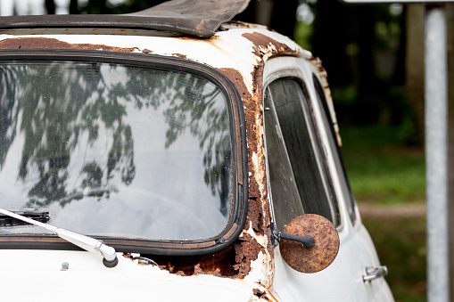 Old rusty destroyed car covered with rust, vintage car.