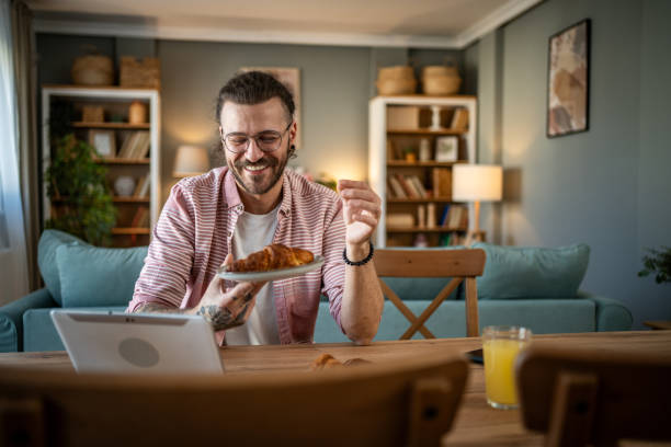 istock A young man eats croissants for breakfast at home 2110419126