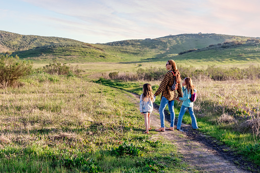 Mom and daughters hiking on a trail