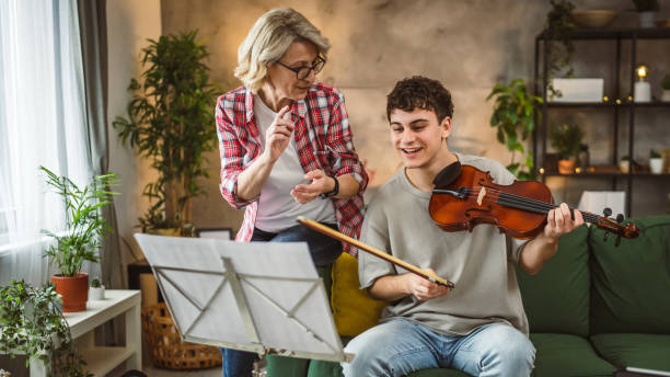 istock Young man learn how to play violin under instruction mature professor 2110503994