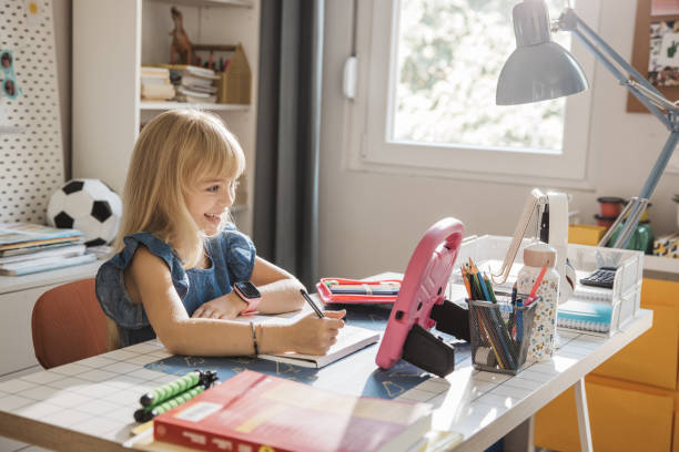 istock Schoolgirl studying at home 2110527151