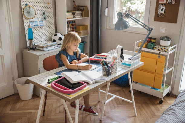 istock Schoolgirl studying at home 2110527152
