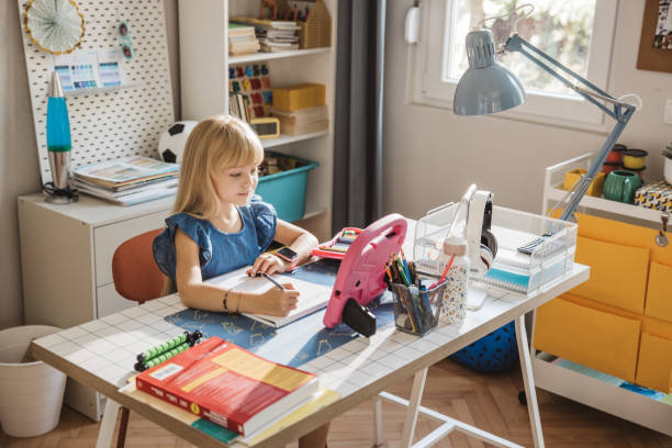istock Schoolgirl studying at home 2110527157
