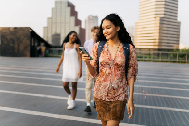 istock Asian female college student texting on phone walking in campus 2110545631