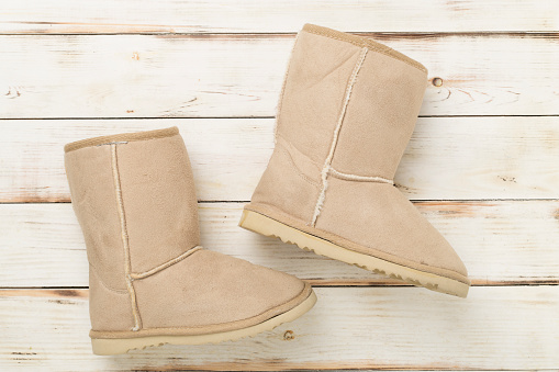 Suede boots on wooden background,top view