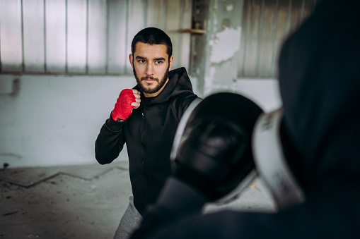 Portrait businessman wearing suite with fighting gloves posing to show combat with competitor in business for successful in purpose