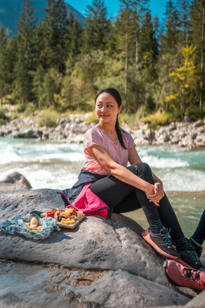 istock Asian Female Hiker Resting on a Rock by Mountain River 2110616684