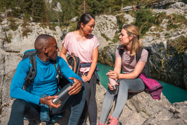 vielfältige gruppe von freunden, die sich während einer outdoor-wanderung ausruhen - 16286 stock-fotos und bilder