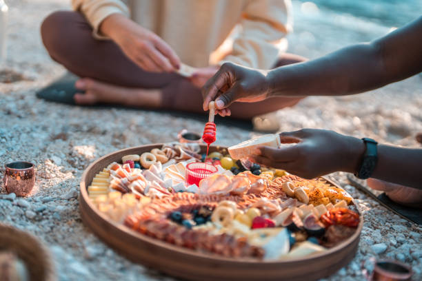 mixed race friends having an outdoors picnic - 16605 imagens e fotografias de stock