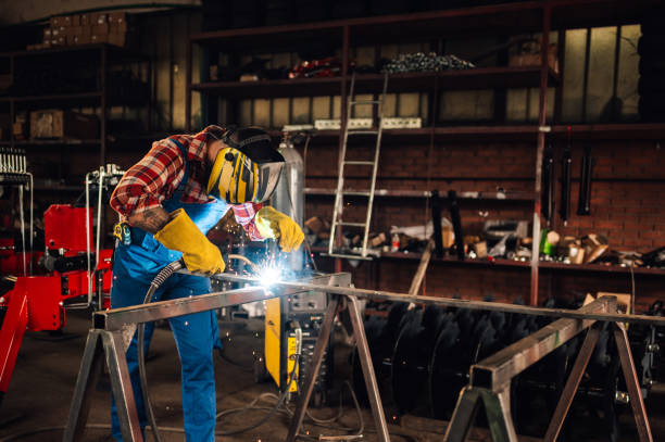 istock Man welding metal with welding machine while wearing a protective gear 2110624535