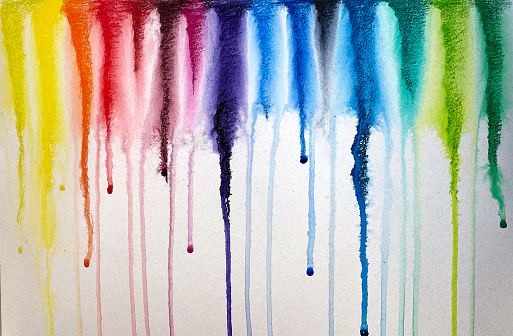 Photo of a watercolor pencil drawing after being sprayed with water, creating a dripping watercolor rainbow