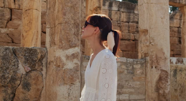 Woman in white dress delves into ancient ruins town