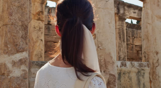 Woman tourist visits ruins of the ancient city of Hierapolis in Turkey