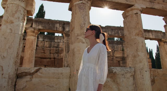 Woman in white dress delves into ancient ruins town