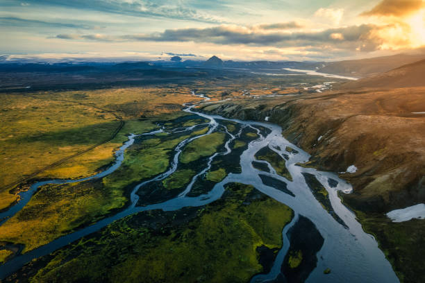 istock Dramatic sunset shines over volcanic mountain with glacier river flowing in Icelandic Highlands 2110772141