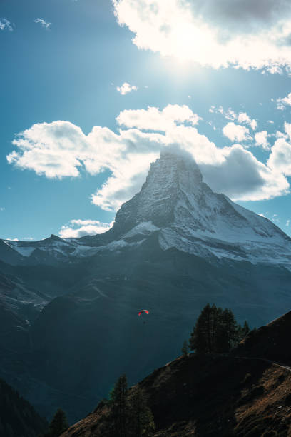 montanha matterhorn com turista jogando paraquedas no céu azul à luz do dia na suíça - findeln - fotografias e filmes do acervo