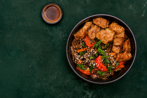 Fried Udon with Chicken and vegetables on dark green background. Asian food. Top view. High quality photo