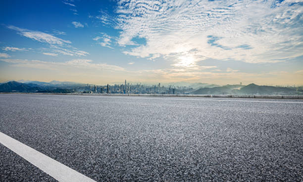 istock Empty asphalt road and modern city skyline with mountains 2110833110