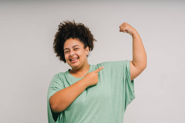 istock Woman showing arm muscle - concept 2110843095
