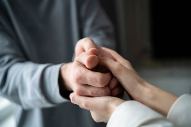 istock Two people engage in a compassionate touch, offering emotional support through a simple but powerful gesture of connected hands. 2110890290