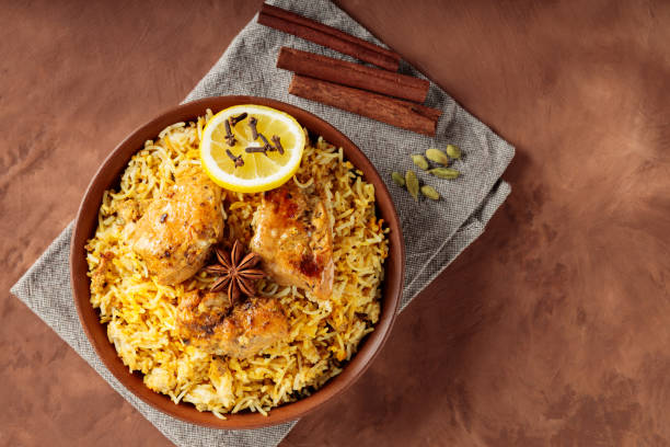 istock Indian Chicken Biryani with Aromatic Spices in Bowl on Brown Background, Copy Space, Top View 2110908298