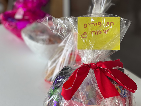 Happy Purim card in Hebrew on Mishloach manot, or shalech mones, and also called a Purim basket, are gifts of food or drink that are sent to family, friends and others Jewish people on Purim day.