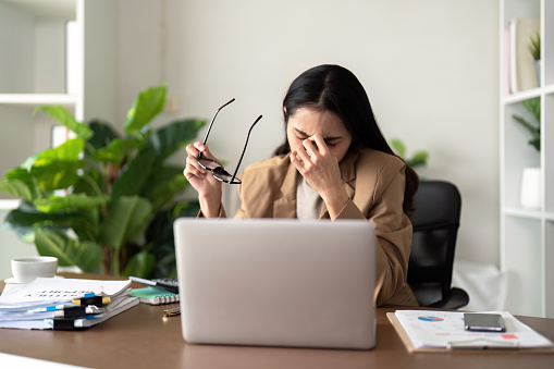 Eco friendly, businesswoman young asian stress in working on laptop while sitting at home office.