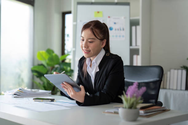 istock Businesswoman in office using tablet computer, audit documents and financial analysis, business people concept 2110952692