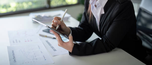 istock Businesswoman in office using tablet computer, audit documents and financial analysis, business people concept 2110953195