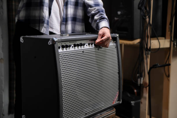 Guitarist Fine-Tunes Amplifier Settings Before a Performance in a Backstage Area
