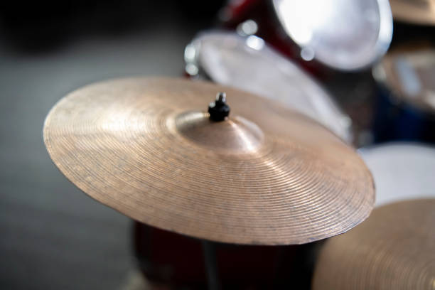 Drum cymbal close-up on a dark blurred background, music concert concept, percussion instrument.
