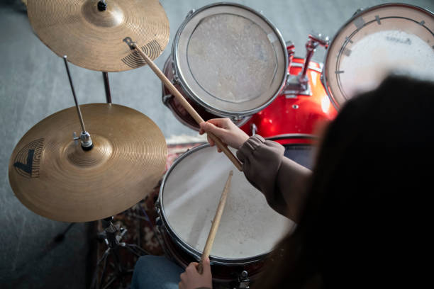 drummers hands holding sticks mid-performance on a drum set - toms стоковые фото и изображения