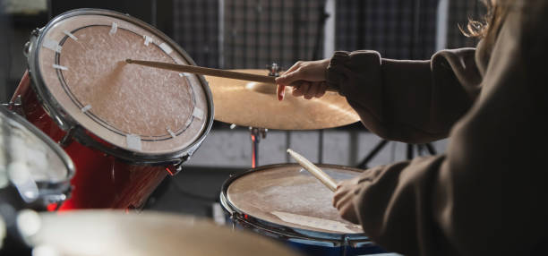 drummers hands holding sticks mid-performance on a drum set - toms imagens e fotografias de stock