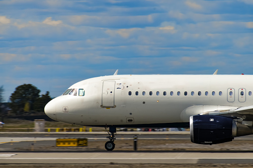 A close up of a passenger jet airplane braking on the runway just after landing.