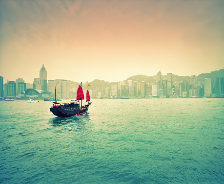 Traditional Chinese junk in Victoria Harbour, with Hong Kong Island in distance, Hong Kong, China