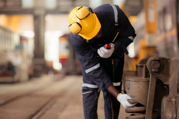 istock Railway technician in uniform and helmet inspect the train wheels removed from the locomotives in the train workshop. 2111151428