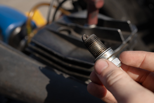 burnt car spark plug in the hands of a mechanic. Automotive children's sports