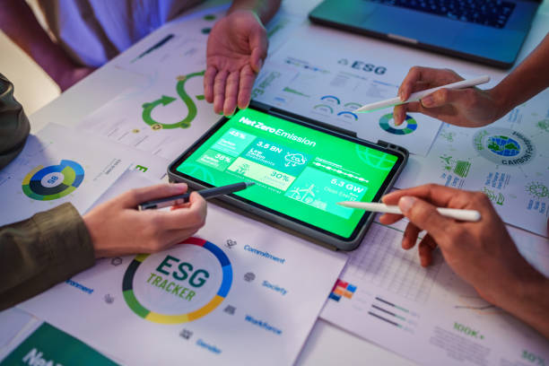 istock close up diversity team brainstorming focused on ESG (environment,social,governance)  with tablet or sdgs goals in a sustainable green office at night 2111171773