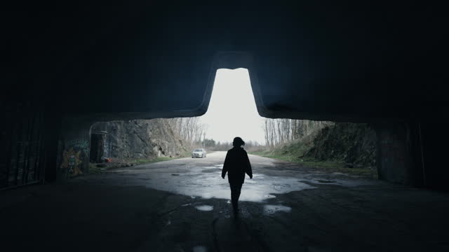 SLO MO Silhouette Woman Walking in Dark Abandoned Underground Zeljava Air Base in Croatia