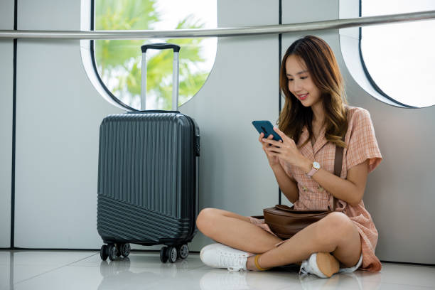 istock Traveler checking her flight and making plans for her trip using her smartphone at the airport 2111200970