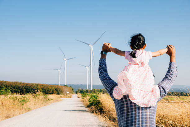 istock Father joyfully carries daughter exploring wind farm 2111201008