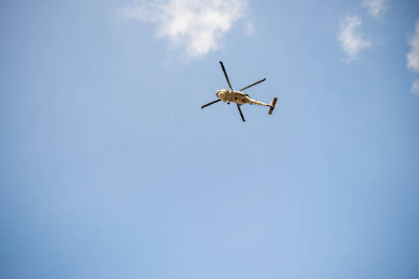 istock Helicopter in flight against blue sky demonstrating modern rescue and transportation technology. New engine hovering capabilities. Pilot manages small aircraft's speed and angles. 2111201543