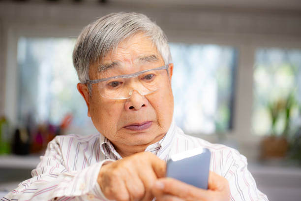 A senior Japanese man who has trouble operating a smartphone